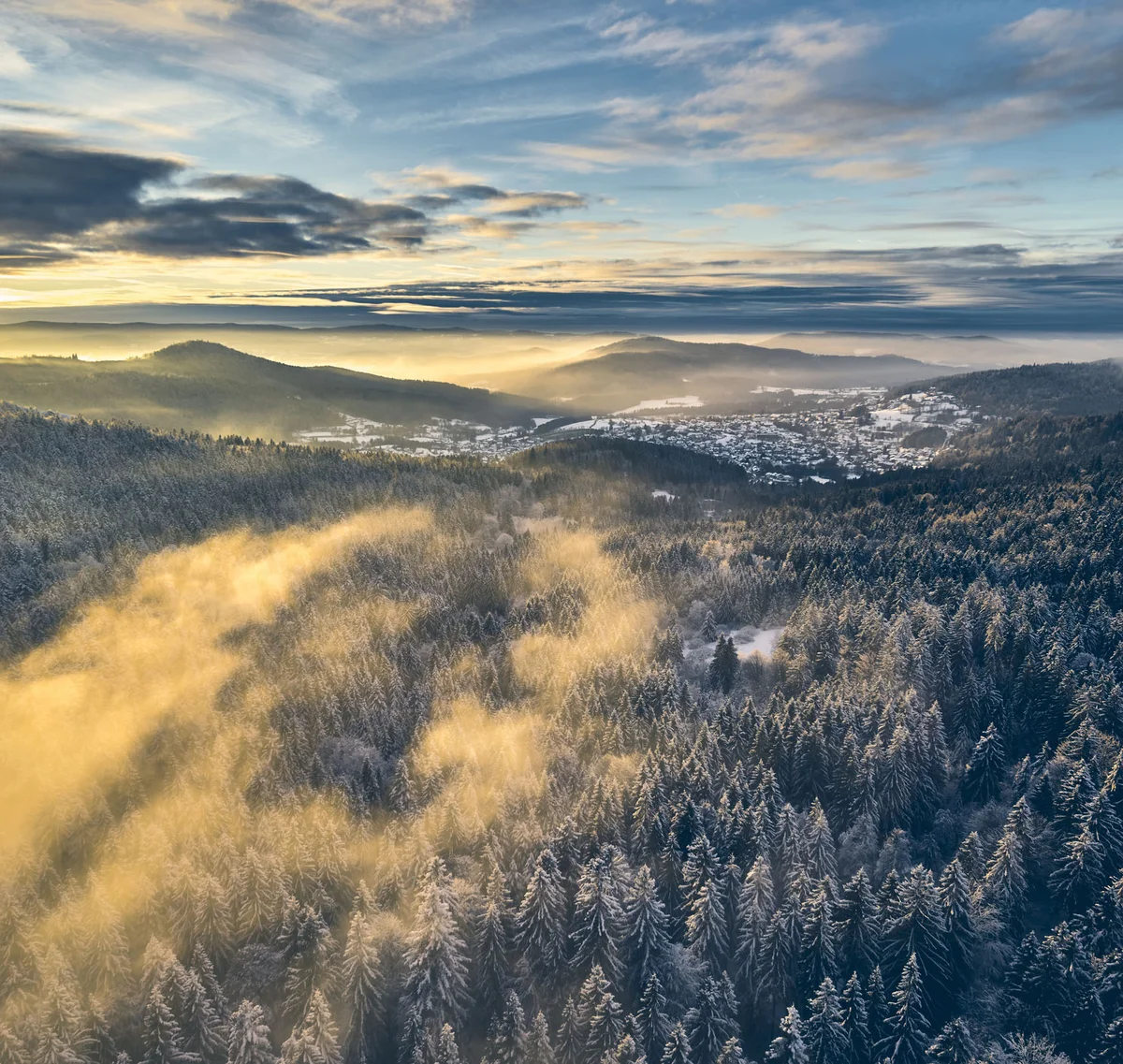 Cubea | Chalet-Apartments in Bodenmais für hohe Ansprüche Sonnenaufgang über verschneitem Wald mit Nebel und Bergen im Hintergrund