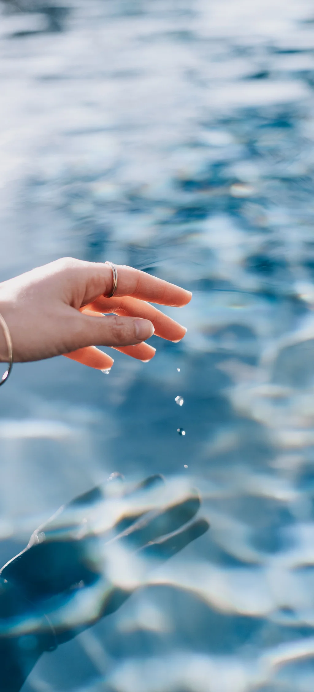 Cubea | Chalet-Apartments in Bodenmais für hohe Ansprüche Hand berührt Wasseroberfläche mit fallenden Wassertropfen