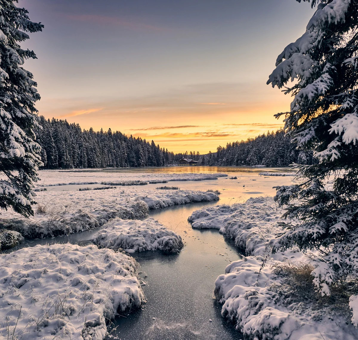 Cubea | Chalet-Apartments in Bodenmais für hohe Ansprüche Verschneite Tannenbäume und ein zugefrorener Fluss bei Sonnenuntergang